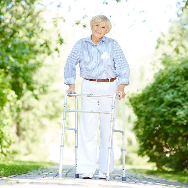 Das Bild zeigt eine ältere Frau mit einer Gehhilfe.