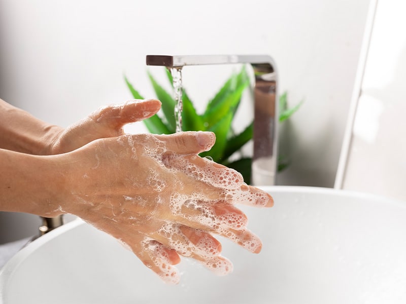 Das Bild zeigt die Hände, welche unter einem Wasserhahn gewaschen werden.